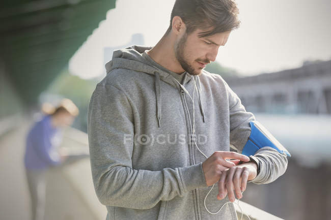Молодий чоловік бігун перевіряє розумний годинник — стокове фото