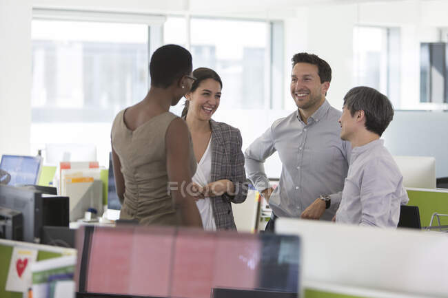 Улыбающиеся деловые люди разговаривают, встречаются в офисе — стоковое фото