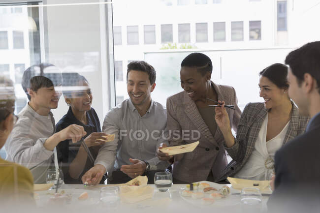 Счастливые бизнесмены наслаждаются суши-ланчем — стоковое фото