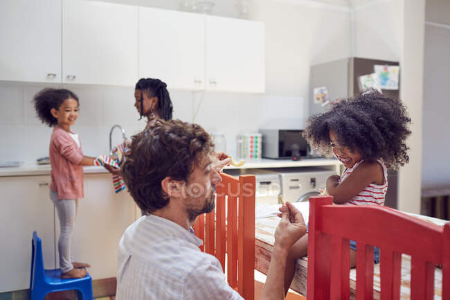 Father feeding toddler daughter in kitchen — Stock Photo