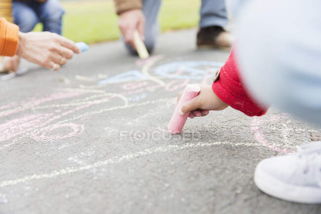 Девушка рисует мелом на тротуаре — стоковое фото