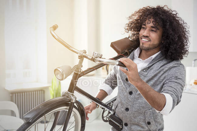 Jovem sorridente carregando bicicleta — Fotografia de Stock