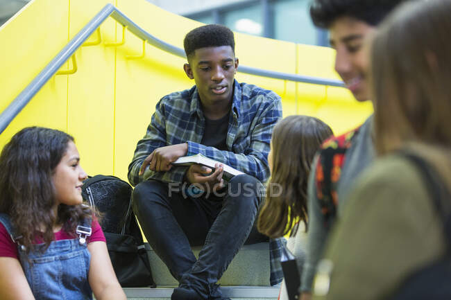 Estudiantes de secundaria hablando en las escaleras - foto de stock