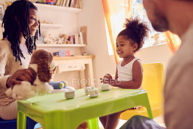 Mother and daughter playing with stuffed animal — Stock Photo