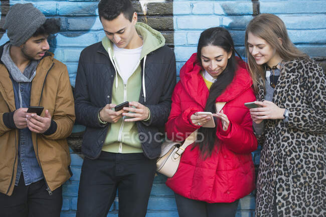 Jovens adultos usando telefones inteligentes — Fotografia de Stock