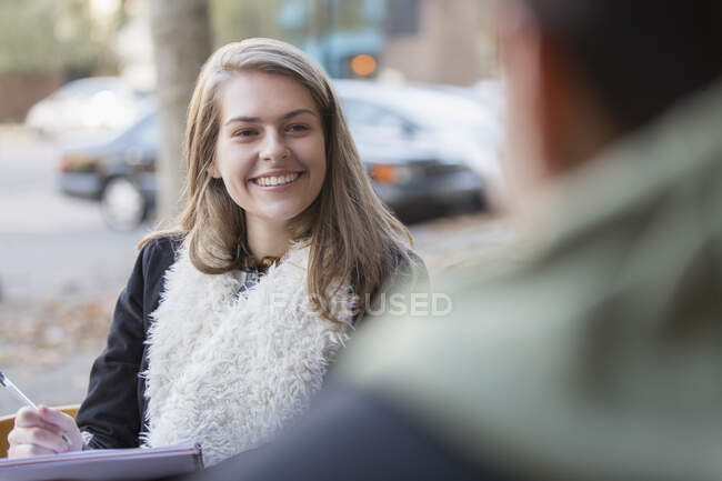Jovem estudante universitária feliz estudando no café calçada — Fotografia de Stock