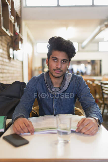 Porträt selbstbewusste junge männliche College-Studentin studiert am Cafétisch — Stockfoto