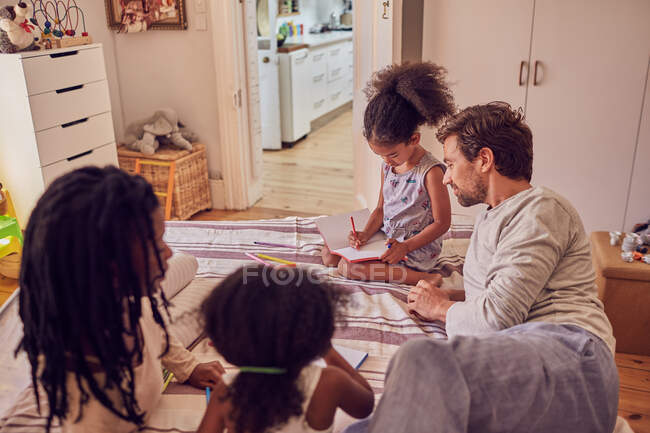 Jovem família coloração na cama — Fotografia de Stock