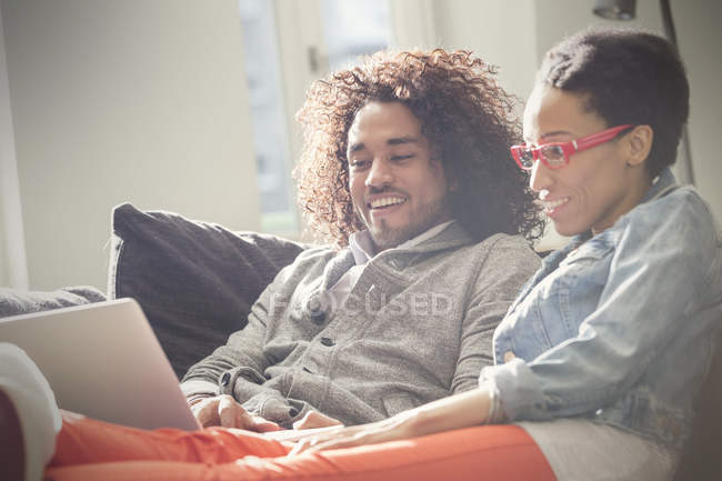Пара отдыха, используя ноутбук на диване — стоковое фото