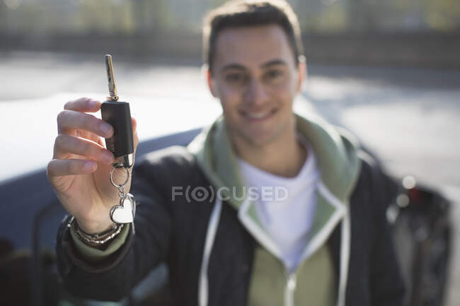 Porträt lächelnder, selbstbewusster junger Mann mit neuem Autoschlüssel — Stockfoto