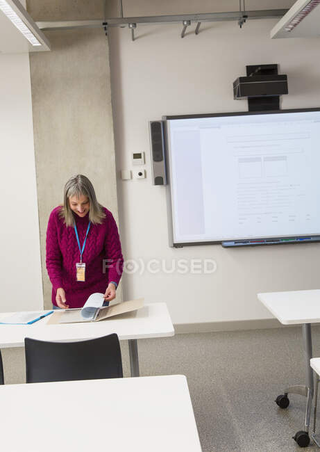 Femme instructrice mature se préparant en classe — Photo de stock