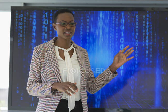 Businesswoman leading meeting at television screen — Stock Photo