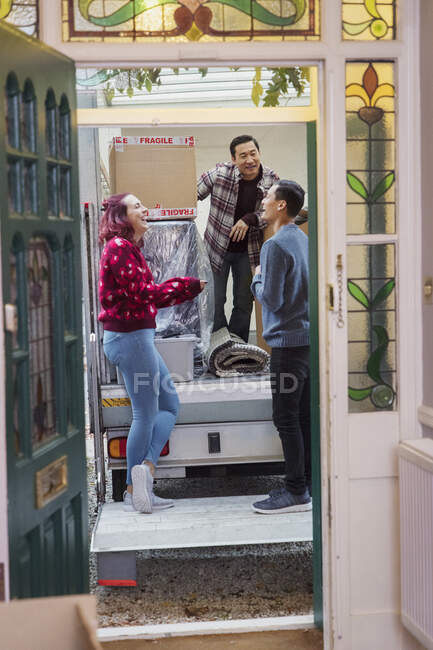 Friends laughing at back of moving van — Stock Photo