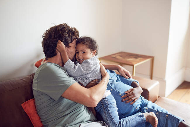 Affettuoso giovane famiglia incinta coccole sul divano — Foto stock