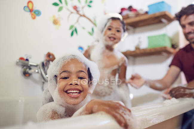 Portrait playful girls taking bubble bath — Stock Photo