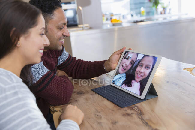 Пара відеоконференцій з дочками на цифровому планшеті на кухні — стокове фото