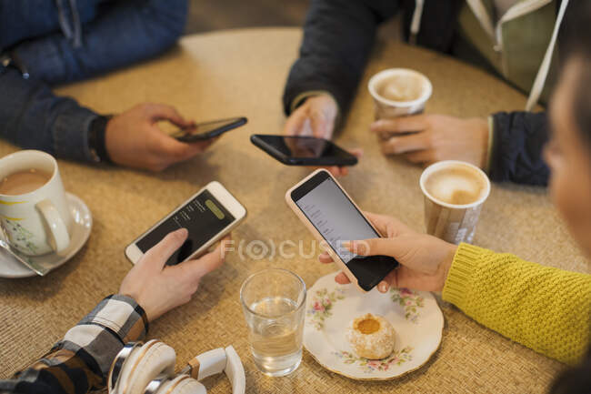 Молоді дорослі друзі користуються розумними телефонами і п 