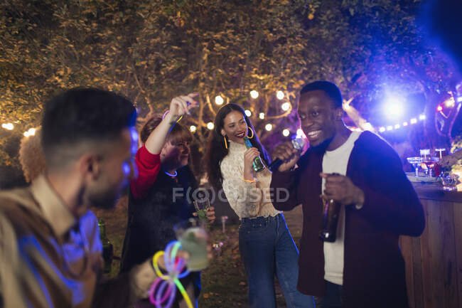 Друзі танцюють і співають караоке на садовій вечірці — стокове фото