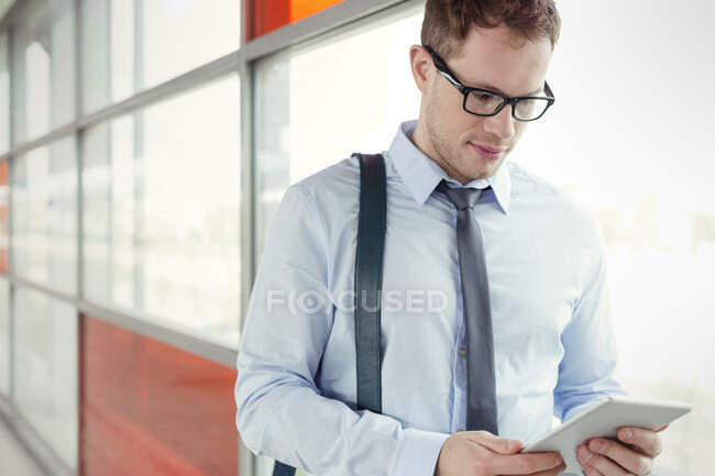 Empresario usando tableta digital en ventana - foto de stock