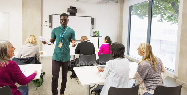 Male community college instructor leading lesson in classroom — Stock Photo
