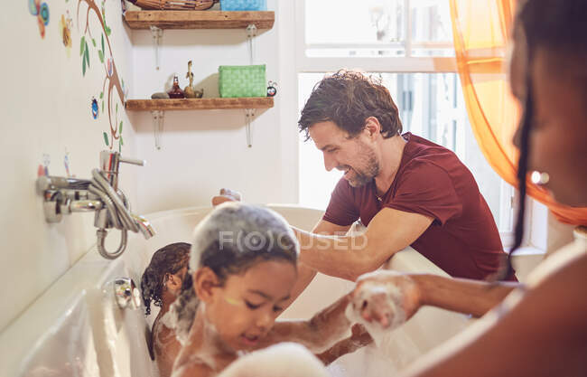 Pais dando banho de espuma de filhas de criança — Fotografia de Stock