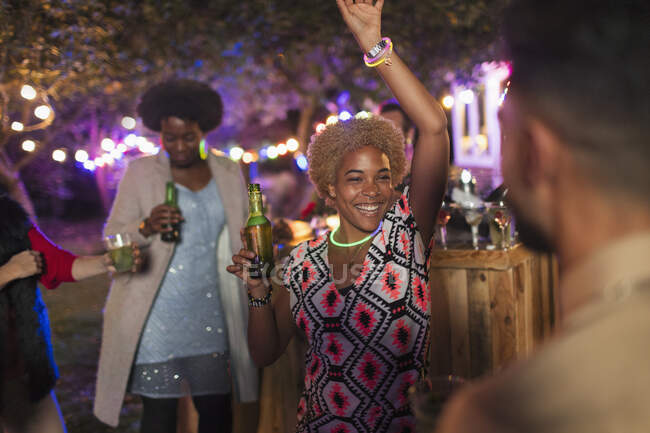 Carefree woman dancing and drinking at garden party — Stock Photo