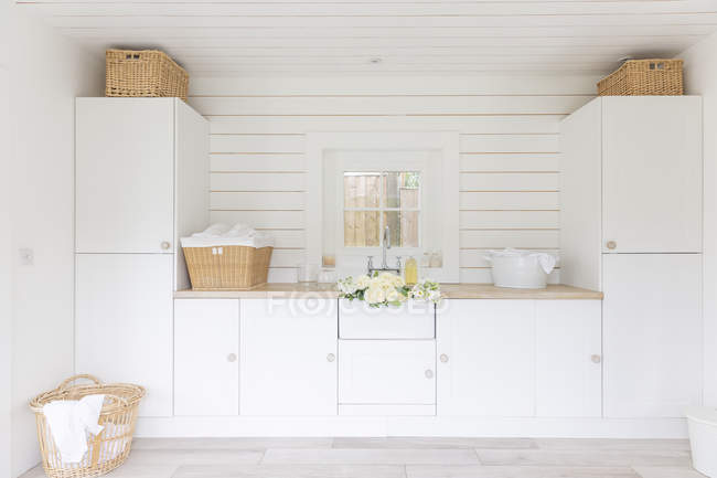 White home showcase laundry room with cupboards and baskets — Stock Photo