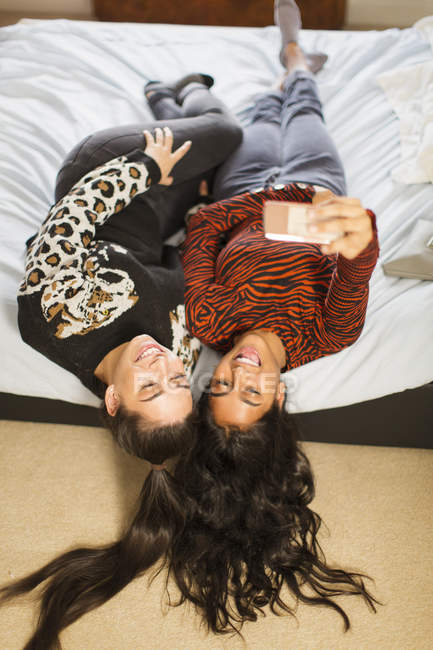 Vista da sopra adolescente ragazza amici prendendo selfie sul letto — Foto stock