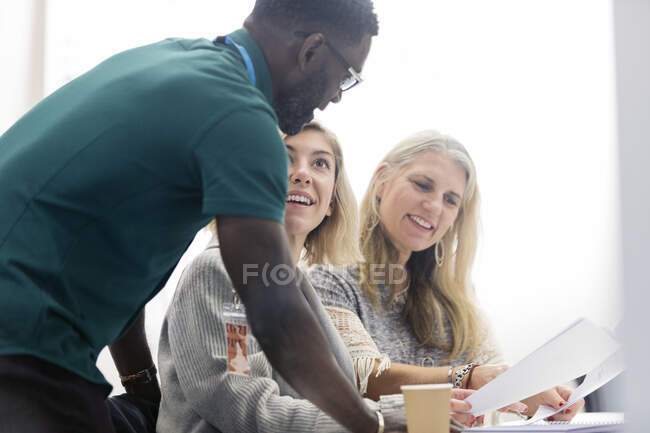 Community college instructor helping students in classroom — Stock Photo