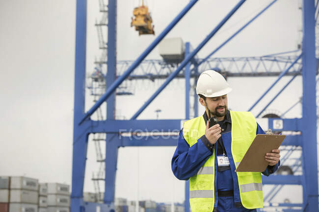 Hafenarbeiter mit Walkie-Talkie und Klemmbrett in der Werft — Stockfoto