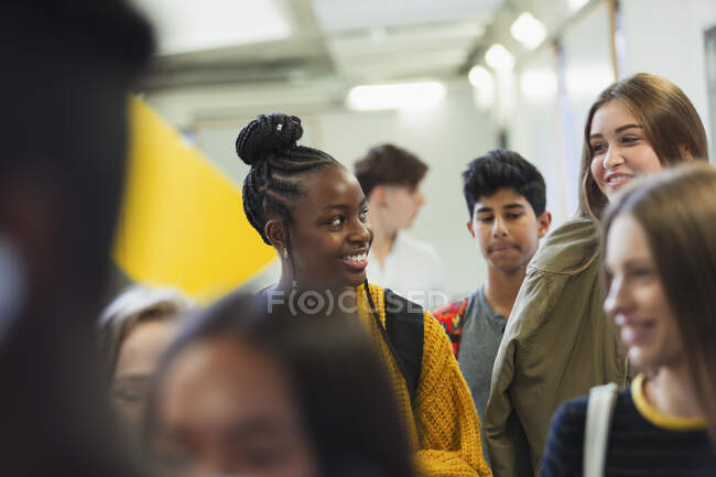 Studenti delle medie che camminano e parlano in corridoio — Foto stock