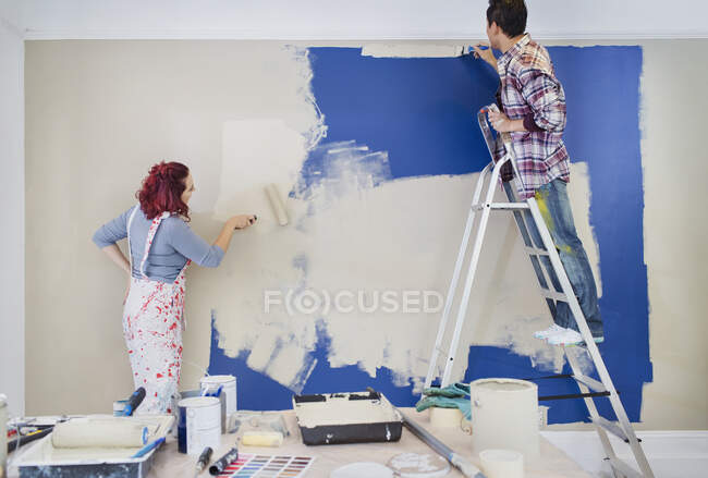 Couple redecorating, painting wall — Stock Photo