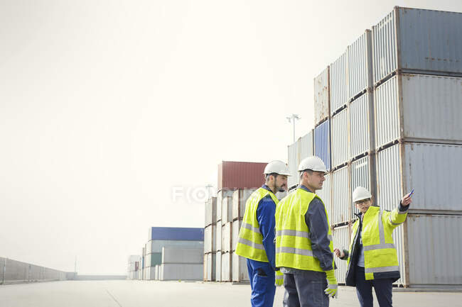 Док-робітники та менеджер розмовляють у вантажних контейнерах на верфі — стокове фото