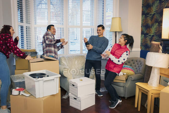 Happy friends moving house, celebrating with champagne — Stock Photo
