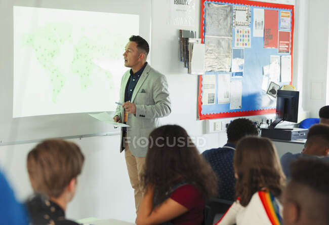 Gymnasiallehrer leitet Geografie-Unterricht an Projektionswand im Klassenzimmer — Stockfoto