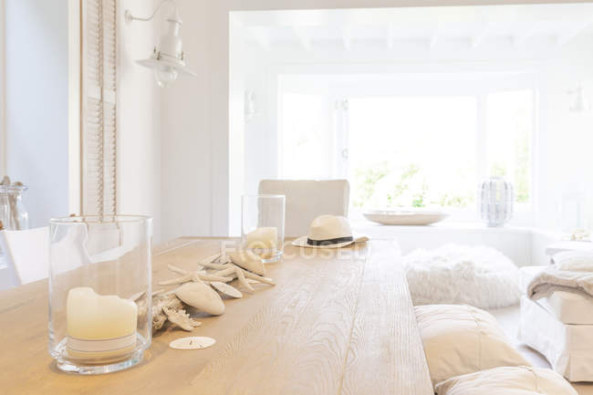 Coquilles et bougies sur table de salle à manger en bois dans la maison vitrine maison de plage — Photo de stock