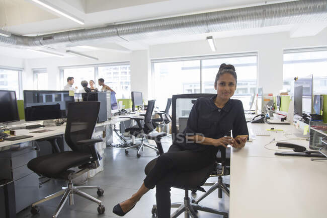 Retrato confiante empresária em plano aberto escritório — Fotografia de Stock