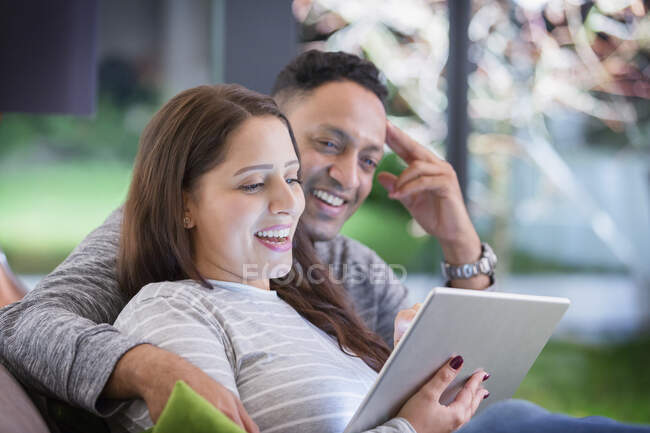 Casal feliz relaxante, usando tablet digital — Fotografia de Stock