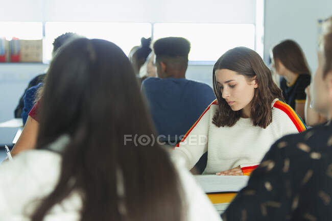 Focalizzato liceale studentessa che studia in classe — Foto stock