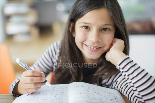 Retrato sorrindo, menina confiante fazendo lição de casa — Fotografia de Stock