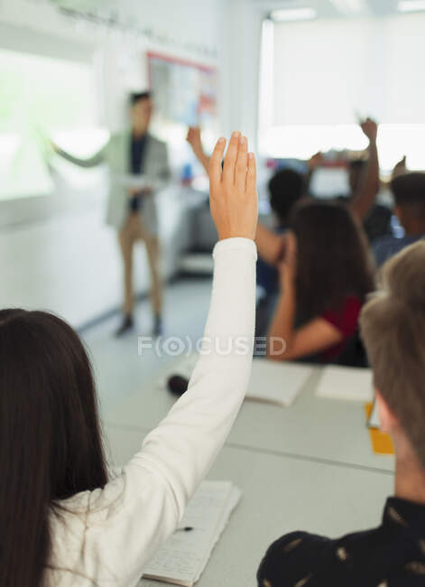 Studentessa del liceo alzando la mano, ponendo domande durante la lezione in aula — Foto stock