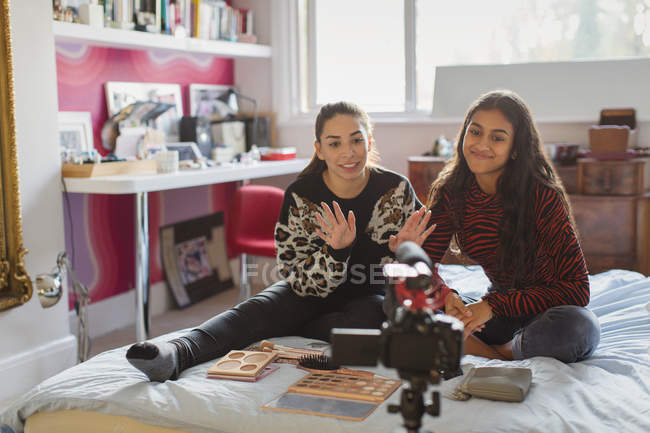 Teenage girl friends vlogging about makeup on bed in bedroom — Stock Photo