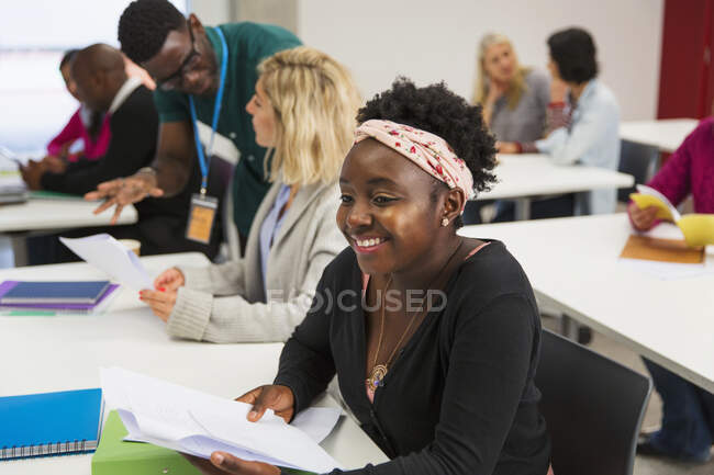 Sonriente, confiada joven estudiante universitaria comunitaria en el aula - foto de stock