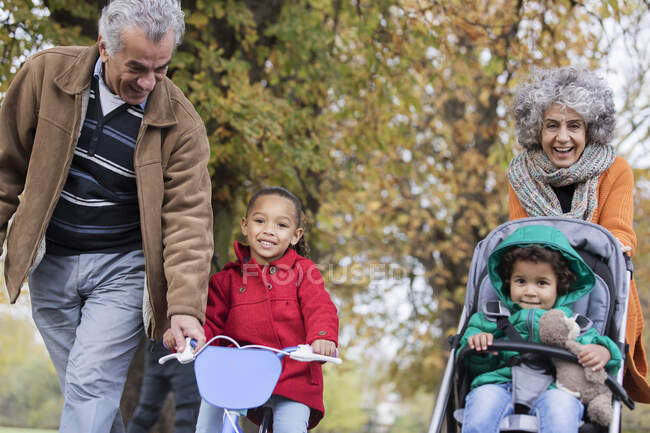 Grands-parents avec petits-enfants dans le parc d'automne — Photo de stock