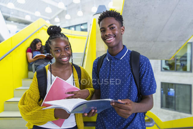 Retrato confiado estudiantes de secundaria que estudian en el pasillo - foto de stock