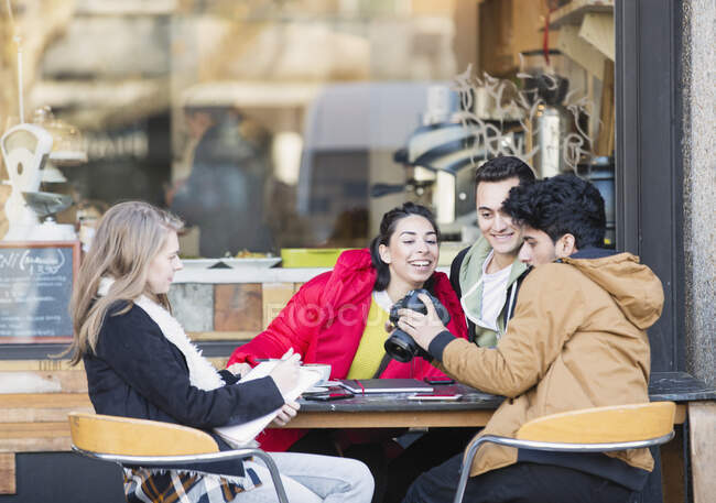 Jóvenes estudiantes universitarios adultos con cámara digital en el café de la acera - foto de stock