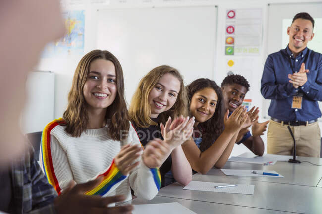 Felices estudiantes de secundaria aplaudiendo en clase de debate - foto de stock