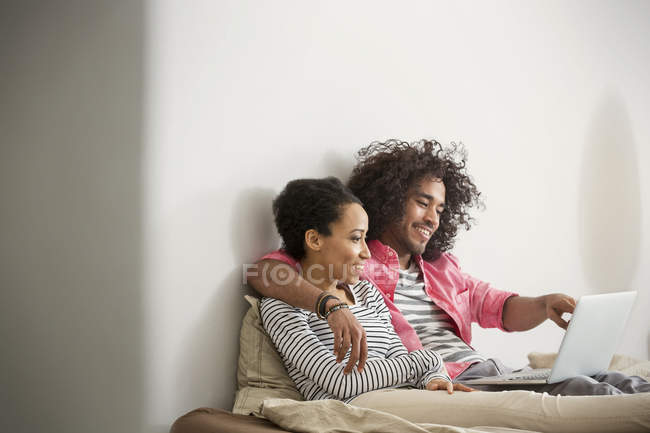 Felice, coppia affettuosa utilizzando il computer portatile sul letto — Foto stock