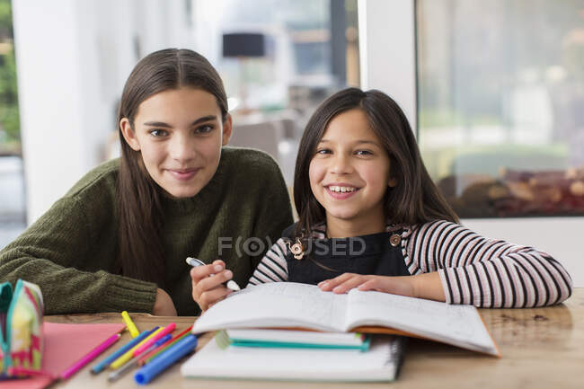 Portrait happy sisters coloring, doing homework — Stock Photo