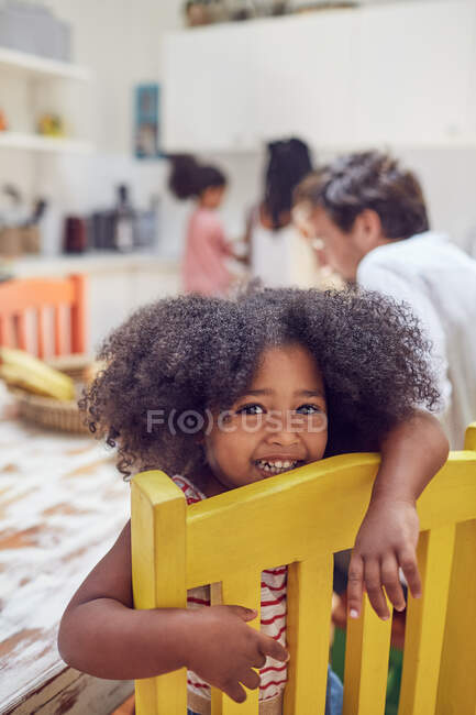 Portrait cute girl on yellow chair — Stock Photo